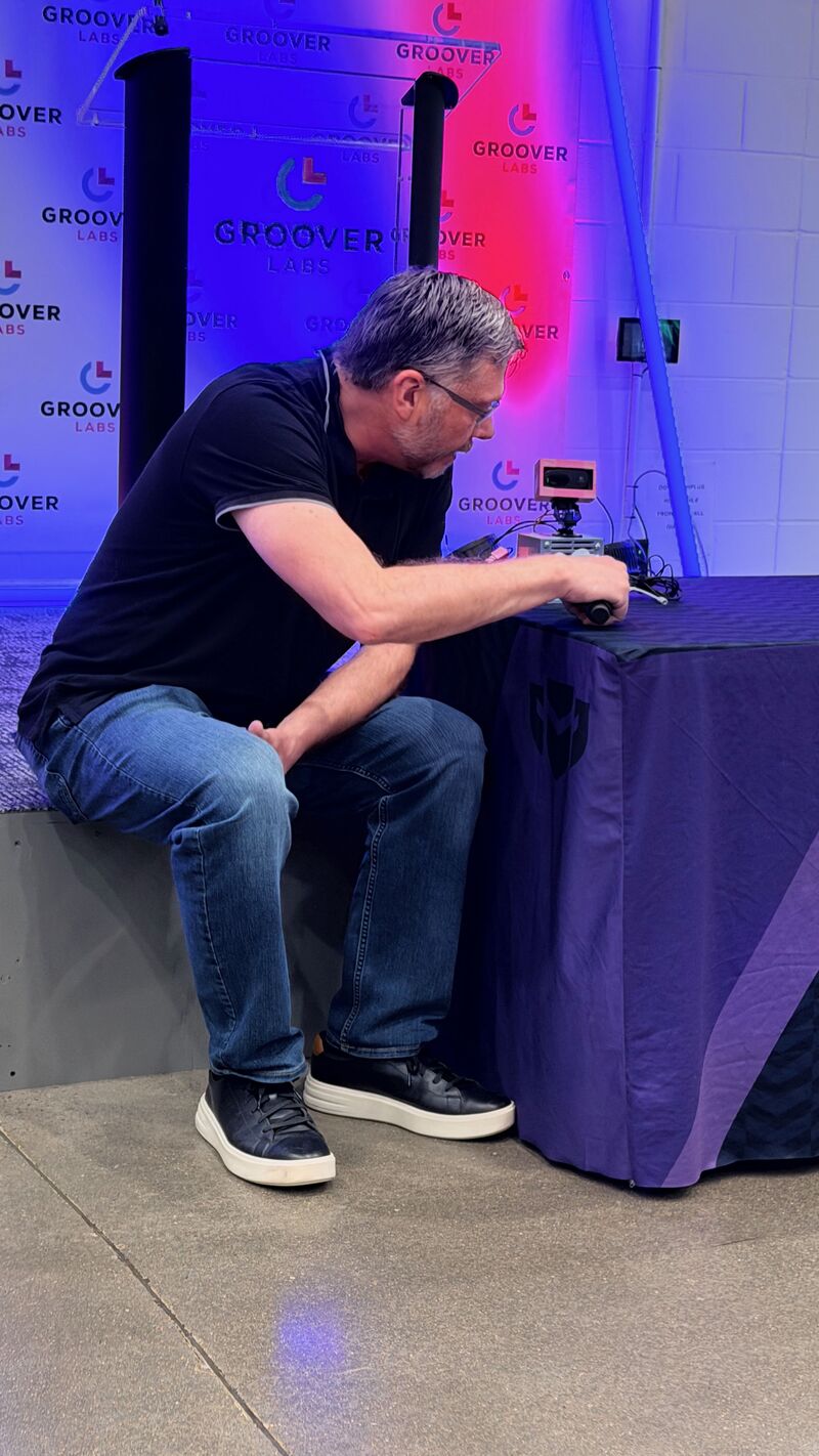 Chad on stage at Groover Labs, leaning toward Droid before the keynote at the Wichita AI Prompt Championship.