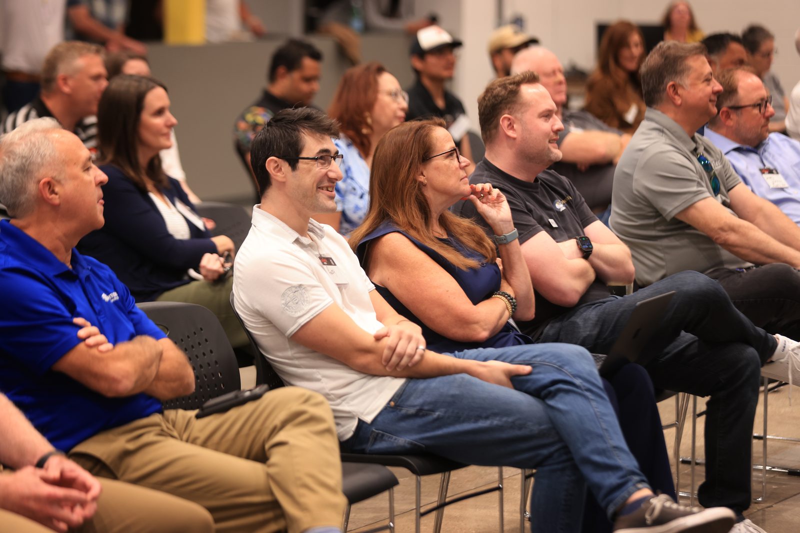 The seated audience at the showcase, smiling and watching a demo.